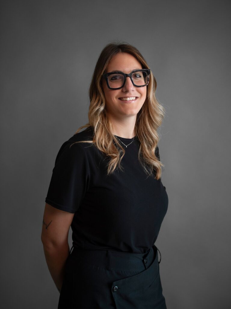 foto di sara, ragazza sorridente, capelli mossi castani, occhiali